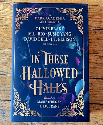 photograph of a copy of In These Hallowed Halls, edited by Marie O'Regan and Paul Kane, lying on a wooden floor