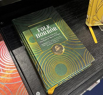 photograph showing a copy of Beyond & Within Folk Horror, edited by Paul Kane and Marie O'Regan, on a black display shelf