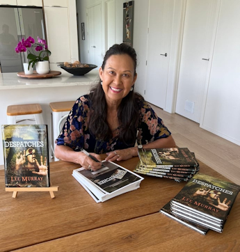 author Lee Murray signing the signing sheets for her Absinthe Books novella, Despatches