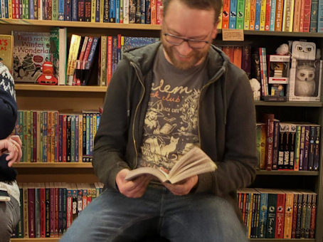 A smiling Mark A. Latham reading from his novel, The Last Vigilant