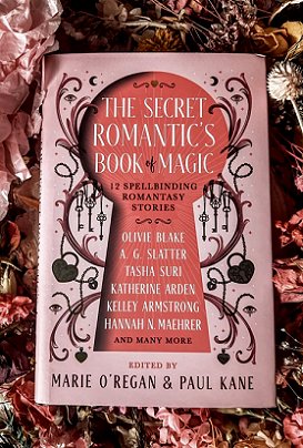 photograph showing a copy of The Secret Romantic's Book of Magic, edited by Marie O'Regan and Paul Kane, ling on a bed of pink dried flowers