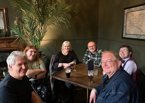 L to R: A smiling Paul Kane, Corinne, Marie O'Regan, Mark Morris, Ben Unsworth and Kevin Mullins, seated around a table