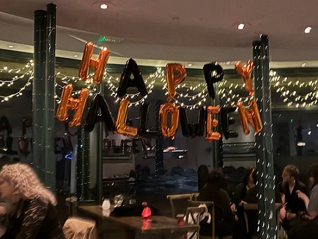 photograph showing Happy Halloween inflated sign hanging in front of a restaurant window